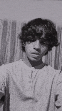 a young man is taking a selfie in front of a curtain .