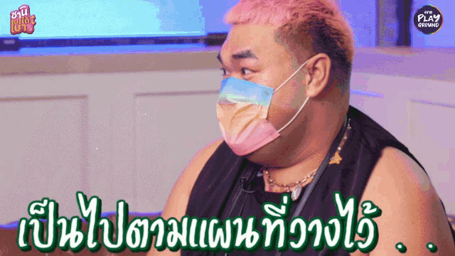 a man with pink hair is wearing a face mask and says play on the bottom right