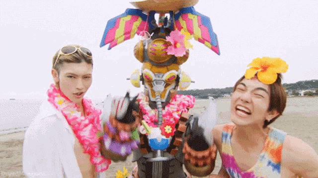 two men are standing next to each other on a beach and one of them is wearing a hawaiian lei .