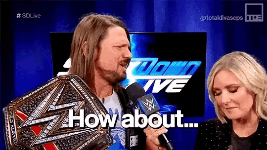 a man is holding a wrestling championship belt while talking into a microphone .