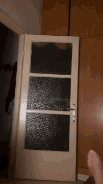 a person is opening a door with a black glass