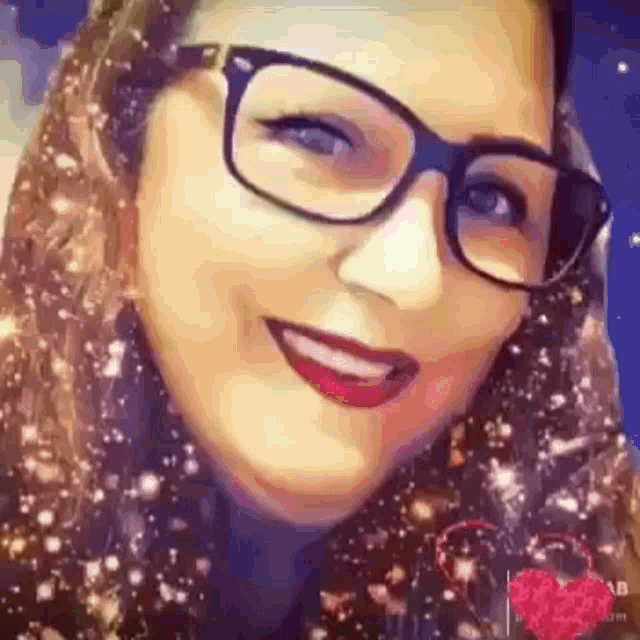a close up of a woman wearing glasses and a scarf smiling .