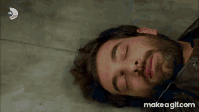 a gif of a man laying on the floor with make a gif.com written on the bottom