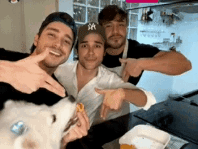 three men are posing for a picture with one wearing a hat with ny on it