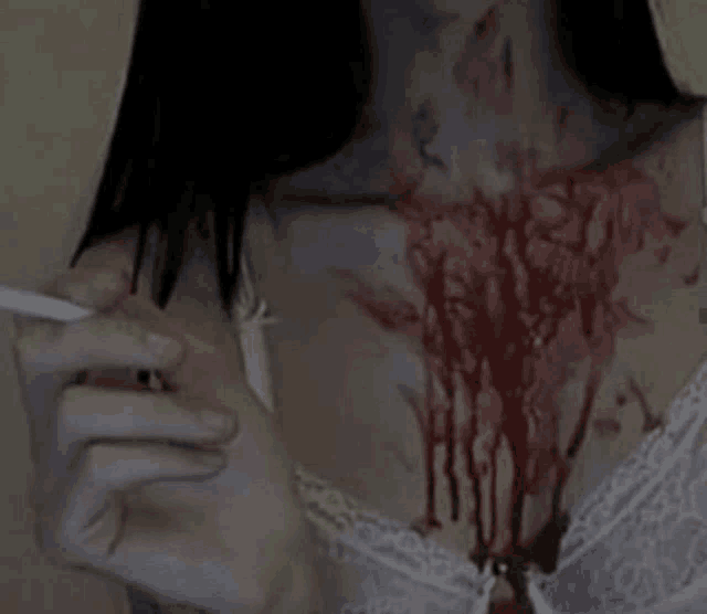 a woman is smoking a cigarette with blood coming out of her chest and neck .