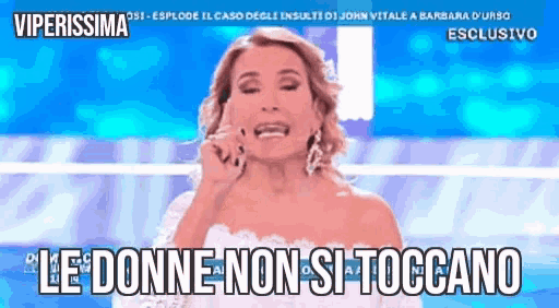 a woman in a white dress is talking on a cell phone with the words le donne non si toccano below her