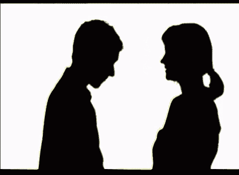 a silhouette of a man and a woman holding hands and looking at each other .