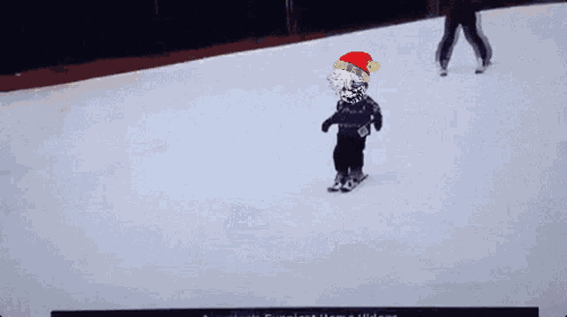 a person wearing a santa hat is skiing down a snow covered slope