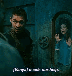 a man and a woman are standing in front of a door and the man says " vanya needs our help "