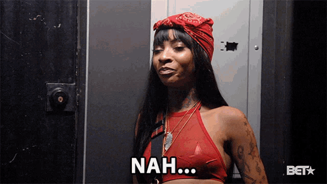 a woman in a red top says " nah " in front of a door
