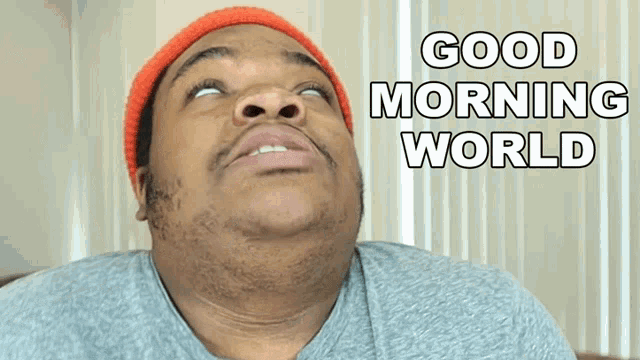 a man wearing an orange beanie looks up at the sky with the words good morning world behind him