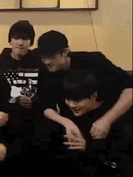 a group of young men are sitting on a couch .