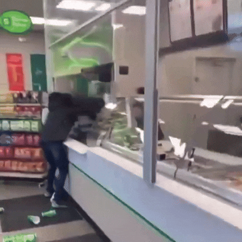 a man is standing in front of a glass counter in a store ..