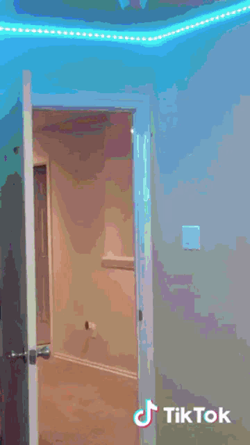 a woman in a pink dress is dancing in a doorway with tiktok written on the bottom
