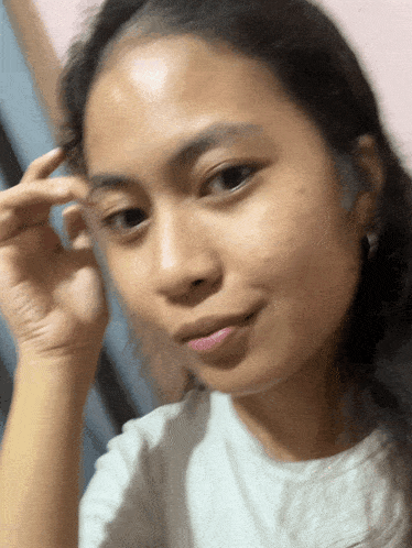 a close up of a woman 's face with a hand on her forehead
