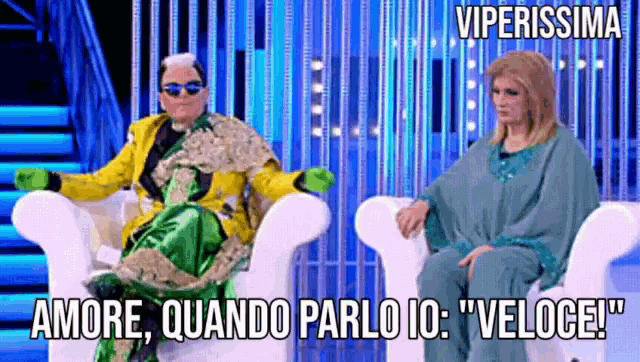 a man in a yellow jacket sits next to a woman in a green outfit with viperissima written on the bottom