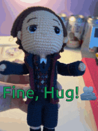 a person is holding a crocheted doll with the words fine hug written on it