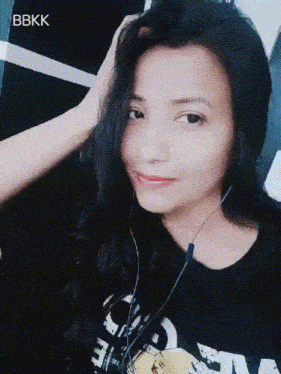 a woman wearing headphones and a shirt that says ' bbkk ' on it