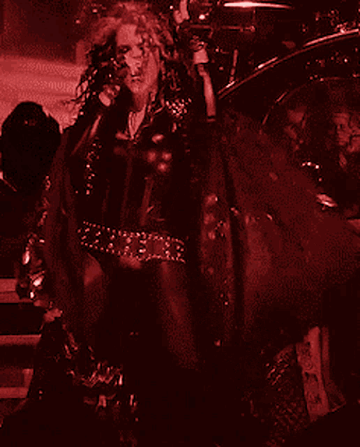 a woman singing into a microphone with a drum in the background