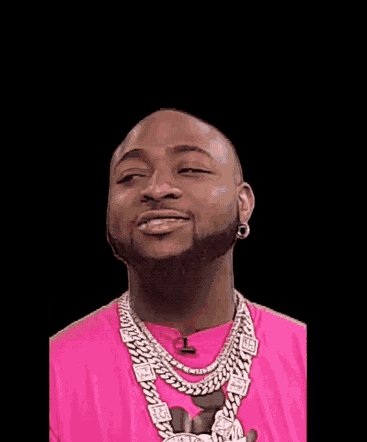 a bald man wearing a pink shirt and a chain around his neck