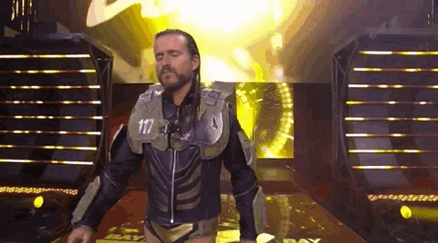 a man in a costume is standing on a stage in front of a crowd .