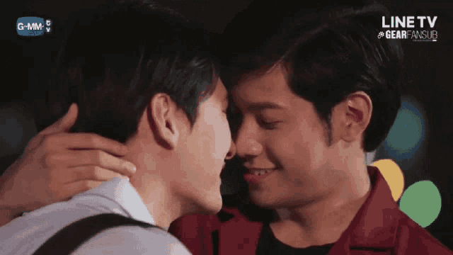 two men are kissing in front of a screen that says line tv on it
