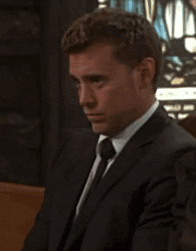 a man in a suit and tie is looking down