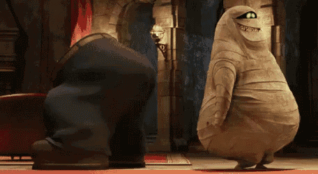 a mummy is dancing with a man in a suit in a room .