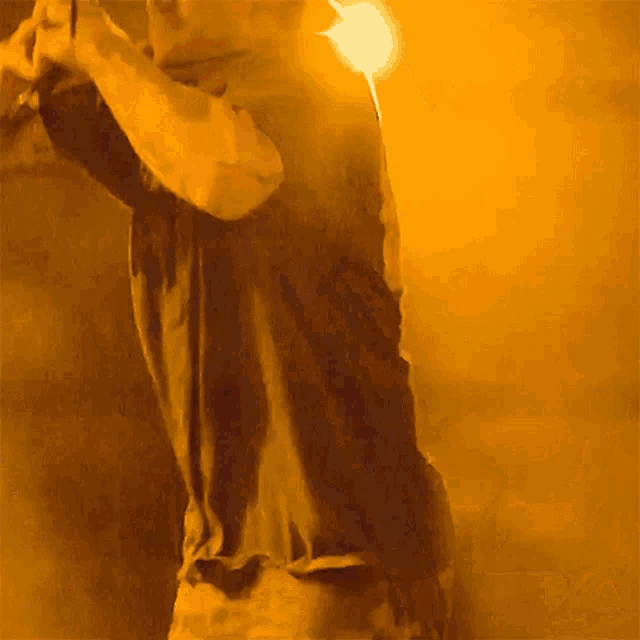 a man in a black shirt stands in front of a yellow background