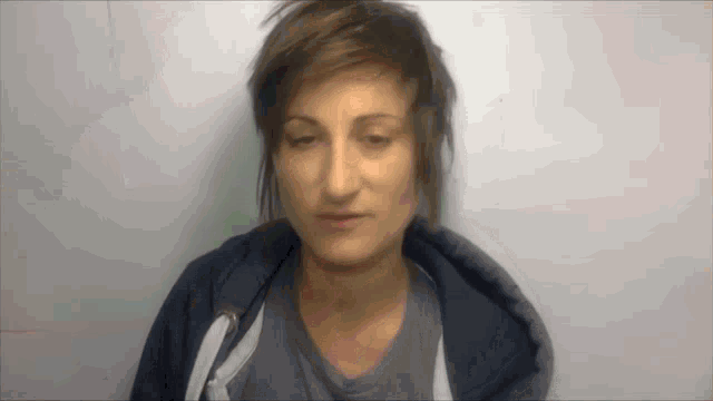 a woman with short hair is wearing a hoodie
