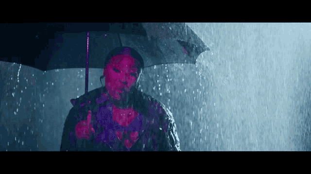 a woman is holding a black umbrella in the rain