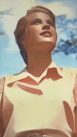 a woman in a white shirt with a red collar is looking up at the sky