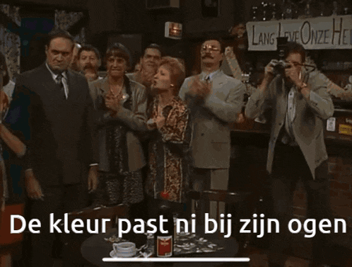 a man and a woman are standing next to each other with the words de kleur past ni bij zijn ogen written on the bottom