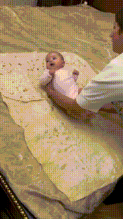 a baby is laying on a large piece of tortilla on a bed