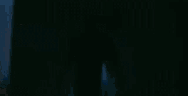a silhouette of a man standing in front of lights