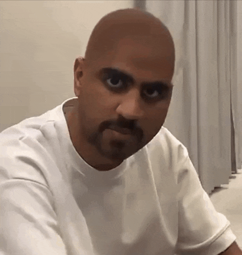a man with a beard is wearing a white shirt