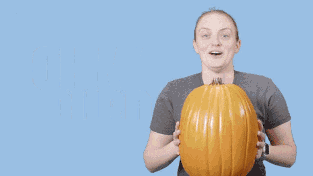 a woman is holding a pumpkin and the words oh my gourd are above her