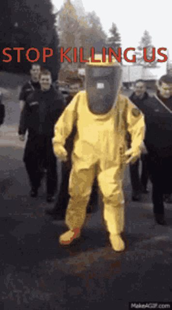 a man in a yellow suit with a mask on his head is walking down the street
