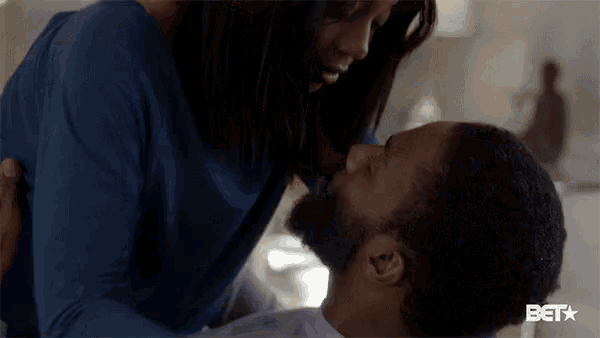 a woman is kissing a man on the cheek .