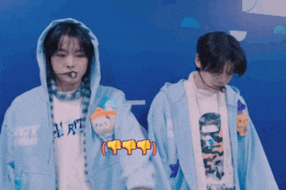 a man wearing a hoodie that says nct stands next to another man