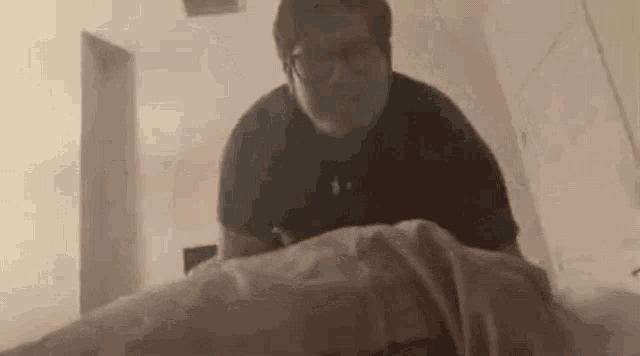 a man is laying on a bed with a blanket on his head .