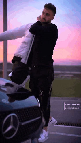 a man standing next to a mercedes with his arm around another man
