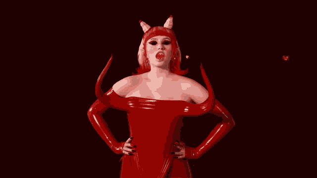 a woman in a red devil costume with horns stands with her hands on her hips