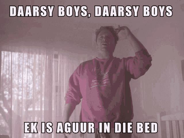 a man in a pink sweatshirt stands in a room with a caption that says daarsy boys daarsy boys