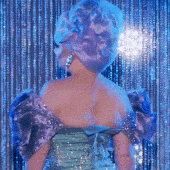 a woman in a purple dress is standing in front of a blue curtain with sequins .