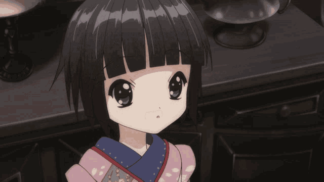 a little girl with black hair and green eyes is wearing a kimono
