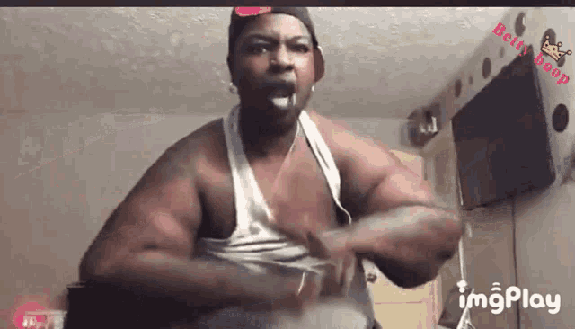 a man in a white tank top is making a funny face with the words imgplay behind him