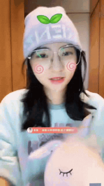 a woman wearing glasses and a hat that says ' mei ' on it