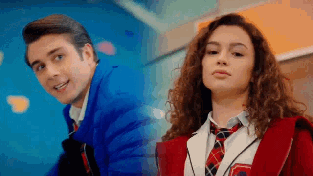 a boy and a girl are standing next to each other and the girl is wearing a plaid tie