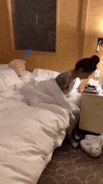 a woman is sleeping on a bed next to a nightstand with a stuffed animal on it